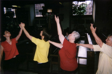 two lines of dancers meet, arms raised